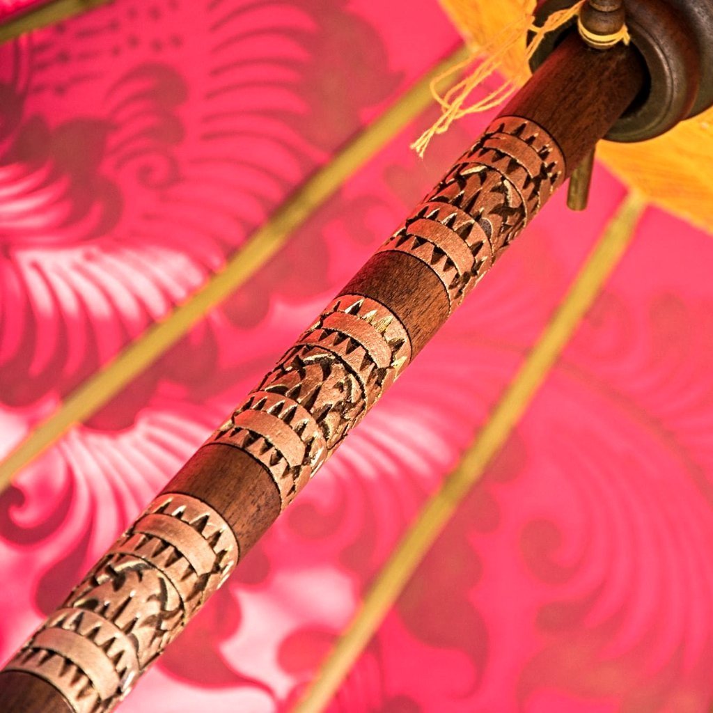 East London parasol company Etta garden parasol or umbrella. Handmade in Bali, orange and gold painted with pink tassels. Wooden framed with carving.
