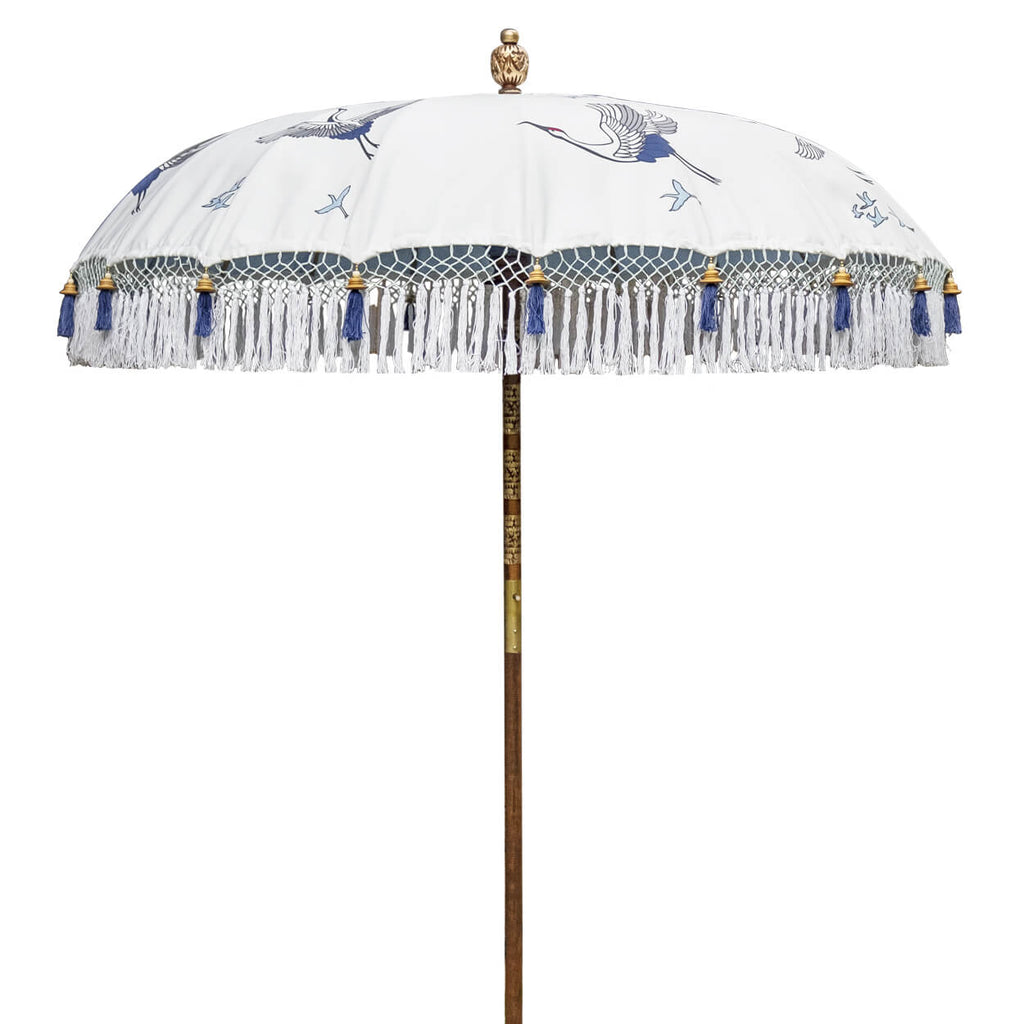 East London Parasol Lexi -blue and white printed soaring cranes garden parasol with tassels in shades of white, hand made. The perfect garden umbrella for picnics, gardens, summer, patios, pool side and terraces. Bali and Indian inspired garden parasol and luxurious designer garden feature.