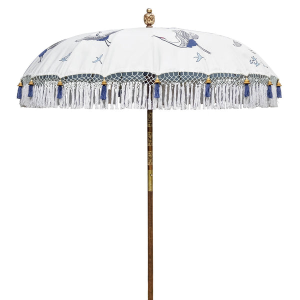 East London Parasol Lexi -blue and white printed soaring cranes garden parasol with tassels in shades of white, hand made. The perfect garden umbrella for picnics, gardens, summer, patios, pool side and terraces. Bali and Indian inspired garden parasol and luxurious designer garden feature.